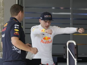 Red Bull driver Max Verstappen, right, of the Netherlands, talks with a crew member as the crew assembles the car for the Formula One U.S. Grand Prix auto race at the Circuit of the Americas, Thursday, Oct. 19, 2017, in Austin, Texas. (AP Photo/Tony Gutierrez)