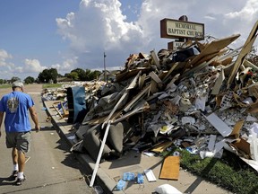 Wayne Christopher walks by a pile of debris outside the church he'd attended his whole life damaged from Hurricane Harvey in Port Arthur, Texas, Monday, Sept. 25, 2017. He and his wife had come here every Sunday and every Wednesday for more than four decades. This church is where he was baptized, where he met his high school sweetheart, then married her 46 years ago. "We have a lot of memories here. This is my home. I've been here all my life," said Christopher. (AP Photo/David Goldman)