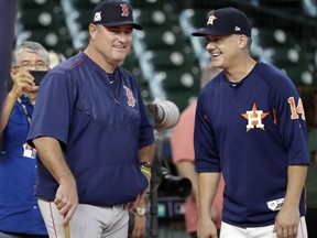 Boston Red Sox manager John Farrell, left, talks with Houston Astros manager A.J. Hinch (14) during practice for baseball's American League Division Series, Wednesday, Oct. 4, 2017, in Houston. The Red Sox will face the Astros Thursday in Game 1 of the ALDS. (AP Photo/David J. Phillip)