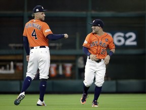 Houston Astros center fielder George Springer (4) and second baseman Jose Altuve (27) prepare for Game 2 of baseball's American League Division Series against the Boston Red Sox, Friday, Oct. 6, 2017, in Houston. (AP Photo/David J. Phillip)