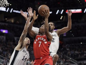 Toronto Raptors guard Kyle Lowry (7) drives to the basket past San Antonio Spurs guard Danny Green (14) and forward LaMarcus Aldridge during the first half of an NBA basketball game Monday, Oct. 23, 2017, in San Antonio. (AP Photo/Eric Gay)