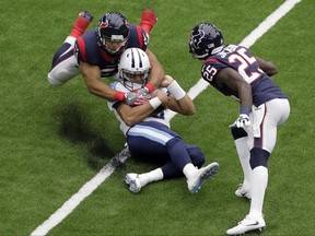 Tennessee Titans quarterback Marcus Mariota, center, is tackled by Houston Texans linebacker Dylan Cole (51) after a short run during the first half of an NFL football game, Sunday, Oct. 1, 2017, in Houston. (AP Photo/Eric Gay)