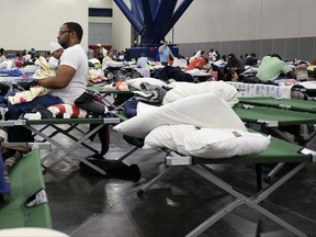 FILE - In this Aug. 29, 2017 file photo, people displaced by Tropical Storm Harvey take shelter in the George R. Brown Convention Center in Houston as Harvey inches its way through the area. The Harvey relief fund established by Houston's top elected leaders has issued its first grants, giving out $7.5 million with an emphasis on getting people still displaced by the storm into temporary housing. Houston Mayor Sylvester Turner, and other leaders of the fund announced the grants Tuesday, Oct. 3, 2017. (Elizabeth Conley/Houston Chronicle via AP)
