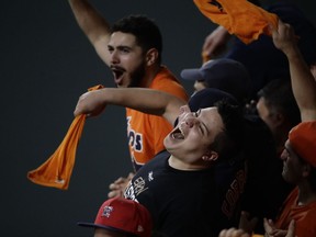 Fans cheer after Houston Astros' Jose Altuve hits a two-run scoring single during the fifth inning of Game 6 of baseball's American League Championship Series against the New York Yankees Friday, Oct. 20, 2017, in Houston. (AP Photo/Charlie Riedel)