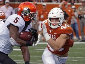 Texas linebacker Breckyn Hager (44) pursues Oklahoma State running back Justice Hill (5) during the first half of an NCAA college football game, Saturday, Oct. 21, 2017, in Austin, Texas. (AP Photo/Michael Thomas)