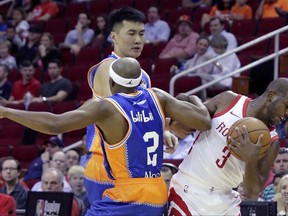 Shanghai Sharks guard Josh Akognon (12) and Zhai Yi (22) tangle with Houston Rockets guard Chris Paul (3) on an attempted steal in the first half of an NBA exhibition basketball game Thursday, Oct. 5, 2017, in Houston. (AP Photo/Michael Wyke)