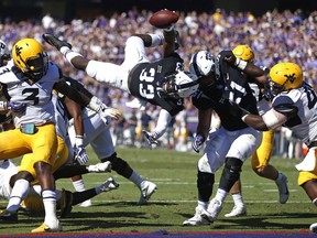 TCU running back Sewo Olonilua (33) dives over the goal line to score a touchdown against West Virginia during the second quarter of an NCAA college football game Saturday, Oct. 7, 2017, in Fort Worth, Texas. (AP Photo/Ron Jenkins)