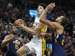 Los Angeles Lakers guard Lonzo Ball, center, drives to the basket as Utah Jazz's Derrick Favors (15) and Rudy Gobert, right, defend in the first half during an NBA basketball game Saturday, Oct. 28, 2017, in Salt Lake City. (AP Photo/Rick Bowmer)