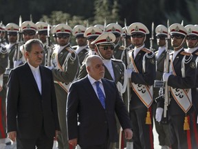 Iraqi Prime Minister Haider al-Abadi, center, reviews an honor guard as he is accompanied by Iranian Senior Vice-President Eshaq Jahangiri, during an official welcoming ceremony for him at the Saadabad Palace in Tehran, Iran, Thursday, Oct. 26, 2017. Haider al-Abadi is in Iran after recent stops in Turkey and Jordan, and meetings with U.S. officials and allies eager to pull Baghdad into their political orbit. (AP Photo/Vahid Salemi)