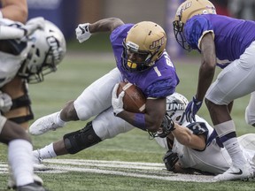James Madison running back Trai Sharp (1) gets pulled down by New Hampshire safety Evan Horn (33) during the first half of an NCAA college football game, Saturday, Oct. 28, 2017 in Harrisonburg, Va. (Daniel Lin/Daily News-Record via AP)