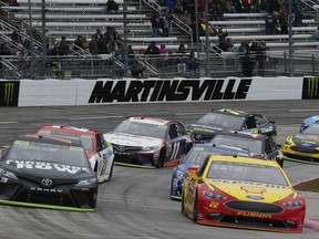 Martin Truex Jr. (78) and Joey Logano (22) are on the front row at the start of the NASCAR Cup series auto race at Martinsville Speedway in Martinsville, Va., Sunday, Oct. 29, 2017. (AP Photo/Steve Helber)
