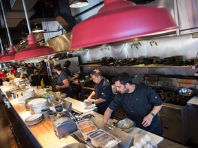 Line cooks Ishaan Kohli, front right, and Abrahan Ruiz, centre, work in the kitchen at Edible Canada restaurant in Vancouver, B.C., on Wednesday October 11, 2017. The restaurant industry may be booming in British Columbia, but a combination of the high cost of living, tight profit margins and a shrinking workforce has made it difficult for kitchens to find enough staff. THE CANADIAN PRESS/Darryl Dyck
