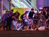 Emergency workers and festival-goers get help for an injured person after the Las Vegas shooting.
