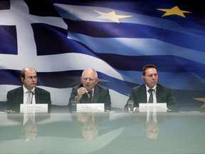 FILE - In this July 18, 2013 file photo, German Finance Minister Wolfgang Schaeuble, center, speaks as his Greek counterpart Yannis Stournaras, right, and Greek Development Minister Kostis Hatzidakis, left, sit alongside him during a news conference at the Greek Finance Ministry, in Athens. Wolfgang Schaeuble, the long-time German finance minister, is attending his final meeting of his peers in the 19-country eurozone on Monday, Oct. 9, 2017. (AP Photo/Petros Giannakouris, File)