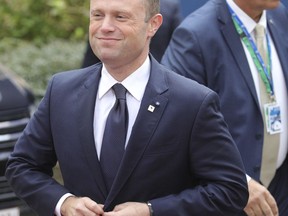 Malta's Prime Minister Joseph Muscat, left, arrives for an EU summit in Brussels on Thursday, Oct. 19, 2017. British Prime Minister Theresa May headed to a European Union summit Thursday with a pledge to treat EU residents well once Britain leaves the bloc. (AP Photo/Olivier Matthys)