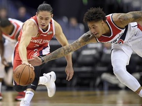 Washington Wizards forward Kelly Oubre Jr., right, reaches for the ball next to Guangzhou Long-Lions' Chen Yingjun during the first half of NBA basketball exhibition game, Monday, Oct. 2, 2017, in Washington. (AP Photo/Nick Wass)
