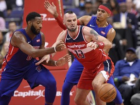 Detroit Pistons center Andre Drummond, left, battles for the ball against Washington Wizards center Marcin Gortat (13), of Poland, during the first half of an NBA basketball game, Friday, Oct. 20, 2017, in Washington. Detroit Pistons forward Tobias Harris is at right rear. (AP Photo/Nick Wass)
