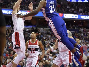 Philadelphia 76ers center Joel Embiid (21) goes to the basket against Washington Wizards forward Jason Smith, left, during the first half of an NBA basketball game, Wednesday, Oct. 18, 2017, in Washington. Smith was charged with a foul on the play.(AP Photo/Nick Wass)