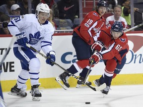 Washington Capitals left wing Andre Burakovsky (65) battles for the puck against Toronto Maple Leafs defenseman Jake Gardiner (51) during the first period of a NHL hockey game, Tuesday, Oct. 17, 2017, in Washington. (AP Photo/Nick Wass)
