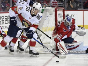 Florida Panthers center Jared McCann (90) works the puck against Washington Capitals goalie Philipp Grubauer (31), of Germany, during the first period of an NHL hockey game, Saturday, Oct. 21, 2017, in Washington. (AP Photo/Nick Wass)