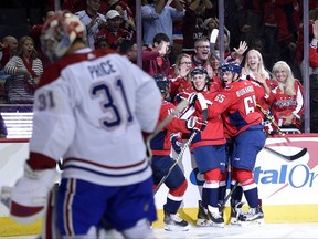 Washington Capitals right wing T.J. Oshie, second from right, celebrates his goal with Andre Burakovsky (65) and others as Montreal Canadiens goalie Carey Price (31) looks away during the first period of a NHL hockey game, Saturday, Oct. 7, 2017, in Washington. (AP Photo/Nick Wass)