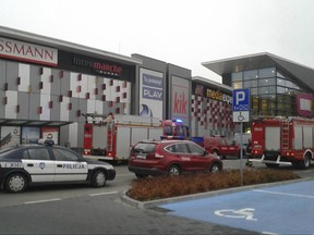 Police and firefighters' cars and trucks stand in front of the VIVO! shopping mall where a 27-year-old man attacked people with a knife killing one person and injuring several others in Stalowa Wola, southeastern Poland, on Friday, Oct. 20, 2017. (AP Photo/Rafal Baran)
