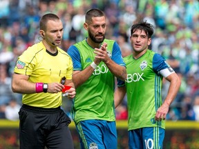 Seattle Sounders midfielder Clint Dempsey (2) walks back with the referee after receiving a red card during the first half of an MLS soccer game against the Colorado Rapids in Seattle on Sunday, Oct. 22, 2017. (Courtney Pedroza/The Seattle Times via AP)