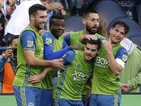 Seattle Sounders' Victor Rodriguez, second from lower right, is greeted by teammates after he scored a goal against FC Dallas in the first half of an MLS soccer match, Sunday, Oct. 15, 2017, in Seattle. (AP Photo/Ted S. Warren)