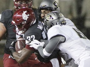 Colorado defensive back Evan Worthington, right, and linebacker Drew Lewis, center, tackle Washington State running back James Williams during the first half of an NCAA college football game in Pullman, Wash., Saturday, Oct. 21, 2017. (AP Photo/Young Kwak)