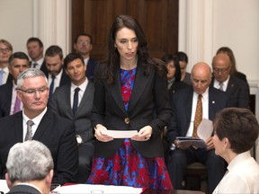 Jacinda Ardern, center, reads the oath as she is sworn in as New Zealand prime minister at a ceremony at Government House in Wellington, New Zealand, Thursday, Oct. 26, 2017. The 37-year-old is New Zealand's youngest leader in more than 150 years and hopes to take the country on a more liberal path following nine years of rule by the conservative National Party. (Mark Mitchell/New Zealand Herald via AP)