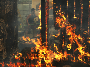 A resident rushes to save his home as an out of control wildfire moves through Glen Ellen, California.