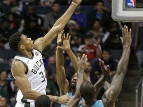 Milwaukee Bucks' Giannis Antetokounmpo shoots over the arms of three Charlotte Hornets during the first half of an NBA basketball game, Monday, Oct. 23, 2017, in Milwaukee. (AP Photo/Tom Lynn)