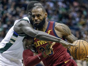 Milwaukee Bucks' Thon Maker, left, reaches in on Cleveland Cavaliers' LeBron James during the first half of an NBA basketball game Friday, Oct. 20, 2017, in Milwaukee. (AP Photo/Tom Lynn)