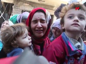 A woman cries as she and her children flee an ISIL-controlled area in Raqqa, Syria, in an image from a video provided on Friday, Oct. 13, 2017, by the Turkey-based Kurdish Mezopotamya news agency media.