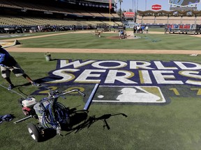 Oscar Del Real paints the World Series logo on the field at Dodgers Stadium before media day for baseball's World Series between the Houston Astros and the Los Angeles Dodgers, Monday, Oct. 23, 2017, in Los Angeles. (AP Photo/David J. Phillip)