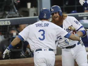 Los Angeles Dodgers' Chris Taylor is congratulated by Justin Turner after hitting a home run during the first inning of Game 1 of baseball's World Series against the Houston Astros Tuesday, Oct. 24, 2017, in Los Angeles. (AP Photo/Alex Gallardo)
