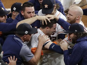 Houston Astros' Alex Bregman is mobbed by teammates after hitting in the game-winning run during the 10th inning of Game 5 of baseball's World Series against the Los Angeles Dodgers Monday, Oct. 30, 2017, in Houston. The Astros won 13-12 to take a 3-2 lead in the series. (AP Photo/Eric Gay)
