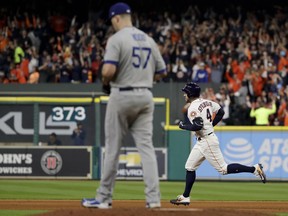 Houston Astros' George Springer, right, rounds the bases after a home run off Los Angeles Dodgers starting pitcher Alex Wood during the sixth inning of Game 4 of baseball's World Series Saturday, Oct. 28, 2017, in Houston. (AP Photo/Matt Slocum)