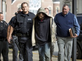 Lawrence County Sheriff Jeff Lawless escorts in Arron Lee Lawson after he was captured on Friday, Oct. 13, 2017, in Ironton, Ohio. Lawson has been arrested on three counts of murder and one count of aggravated murder.(Sholten Singer/The Herald-Dispatch via AP)