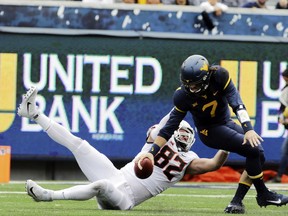 Oklahoma State defensive end Cole Walterscheid (82) sacks West Virginia quarterback Will Grier (7) during the first half of an NCAA college football game, Saturday, Oct. 28, 2017, in Morgantown, W.Va. (AP Photo/Raymond Thompson)