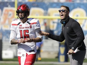 Texas Tech head coach Kliff Kingsbury gives instructions to quarterback Nic Shimonek (16) during the first half of an NCAA college football game against West Virginia, Saturday, Oct. 14, 2017, in Morgantown, W.Va. (AP Photo/Raymond Thompson)
