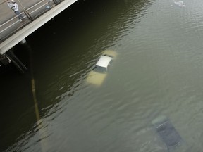 FILE - In this Aug. 27, 2017, file photo, people look at submerged cars on a freeway flooded by Tropical Storm Harvey near downtown Houston, Texas. After Hurricanes Harvey, Irma and Maria blitzed the nation, most Americans think weather disasters are getting more severe and they see global warming's fingerprints all over them. A new poll by the Associated Press-NORC Center for Public Affairs Research says 68 percent of those surveyed think weather disasters seem to be worsening, compared to 28 percent who think they are staying the same and only 4 percent who say they are less severe. (AP Photo/Charlie Riedel, File)