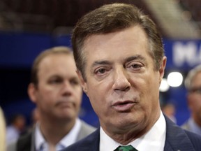 FILE - In this July 17, 2016 file photo, Trump campaign chairman Paul Manafort talks to reporters on the floor of the Republican National Convention at Quicken Loans Arena in Cleveland as Rick Gates, a former business associate to Manafort and former campaign aide to Republican presidential candidate Donald Trump, listens at back left. (AP Photo/Matt Rourke, File)