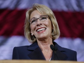 In this Oct. 13, 2017 photo, Education Secretary Betsy DeVos speaks during a dinner hosted by the Washington Policy Center in Bellevue, Wash. A group of 18 states is suing the U.S. Department of Education over its decision to block an Obama-era rule designed to protect students from being defrauded by for-profit colleges.  (AP Photo/Ted S. Warren)