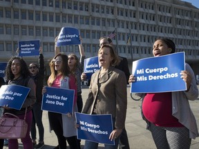 FILE - In this Oct. 20, 2017, photo, activists with Planned Parenthood demonstrate in support of a pregnant 17-year-old being held in a Texas facility for unaccompanied immigrant children to obtain an abortion, outside of the Department of Health and Human Services in Washington. A federal appeals court on Oct. 24 cleared the way for a 17-year-old immigrant held in custody in Texas to obtain an abortion. The full U.S. Court of Appeals for the District of Columbia Circuit ruled 6-3 in favor of the teen. The decision overturned a ruling by a three-judge panel of the court that at least temporarily blocked her from getting an abortion. The Trump administration could still appeal the decision to the Supreme Court. (AP Photo/J. Scott Applewhite)