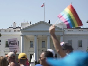 In this Sunday, June 11, 2017 file photo, Equality March for Unity and Pride participants march past the White House in Washington