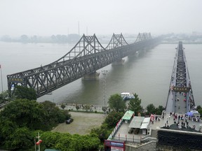 FILE - In this Sept. 9, 2017, file photo, visitors walk across the Yalu River Broken Bridge, right, next to the Friendship Bridge connecting China and North Korea in Dandong in northeastern China's Liaoning province. China's increasingly icy posture is thrusting Russia forward as North Korea's preferred diplomatic partner, forcing the Trump administration to turn to Moscow for help in isolating the rogue, nuclear-armed nation. Beijing's close ties to Pyongyang have been strained since leader Kim Jong Un ordered the 2013 execution of his uncle who had been the countries' chief liaison. Since then, the allies once said to be as "close as lips and teeth" have moved further apart over China's adoption of U.N. sanctions designed to starve North Korea of revenue for its nuclear and missile programs. (AP Photo/Emily Wang, File)