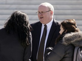 FILE - In this March 21, 2016, file photo, attorney Marc Elias, one of several lawyers who appeared in the in the case of Wittman v. Personhuballah, stands on the plaza of the Supreme Court in Washington. Hillary Clinton's presidential campaign and the Democratic National Committee helped fund a political research firm that produced a dossier of allegations about President Donald Trump's ties to Russia. That's according to a person familiar with the situation who spoke on Oct. 24, 2017, to The Associated Press. The person says the arrangement, first reported by The Washington Post, was coordinated by a lawyer for the campaign and the DNC and his law firm. That lawyer, Marc Elias, did not immediately return an email seeking comment. (AP Photo/J. Scott Applewhite)