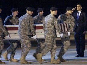 FILE - In this Oct. 29, 2009, file photo President Barack Obama, right, salutes as an Army carry team carries the transfer case containing the remains of Sgt. Dale R. Griffin of Terre Haute, Ind., during a casualty return at Dover Air Force Base, Del. President Donald Trump is claiming his predecessors did not sufficiently honor the nation's fallen. His accusation that most presidents did not call families of military personnel is provoking a heated response. Obama, for one, visited the air base that often receives the remains of the dead. He wrote letters to military families, too. Obama's office says Trump is "unequivocally wrong."(AP Photo/Pablo Martinez Monsivais, File)