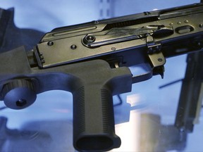 In this Oct. 4, 2017, photo, a device called a "bump stock" is attached to a semi-automatic rifle at the Gun Vault store and shooting range in South Jordan, Utah. The National Rifle Association announced its support Ton Oct. 5 for regulating the devices that can effectively convert semi-automatic rifles into fully automated weapons and that were apparently used in the Las Vegas massacre to lethal effect. It was a surprising shift for the leading gun industry group, which in recent years has resolutely opposed any gun regulations. Immediately afterward the White House, too, said it was open to such a change. (AP Photo/Rick Bowmer)